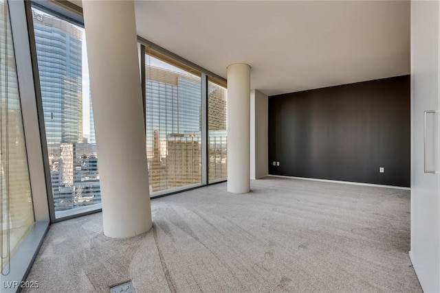 carpeted spare room with floor to ceiling windows