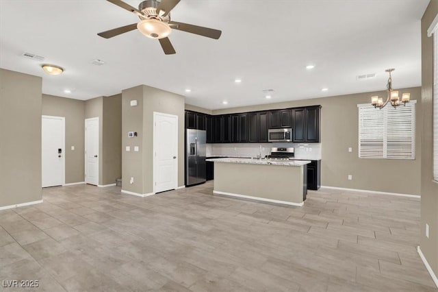 kitchen with open floor plan, appliances with stainless steel finishes, and baseboards