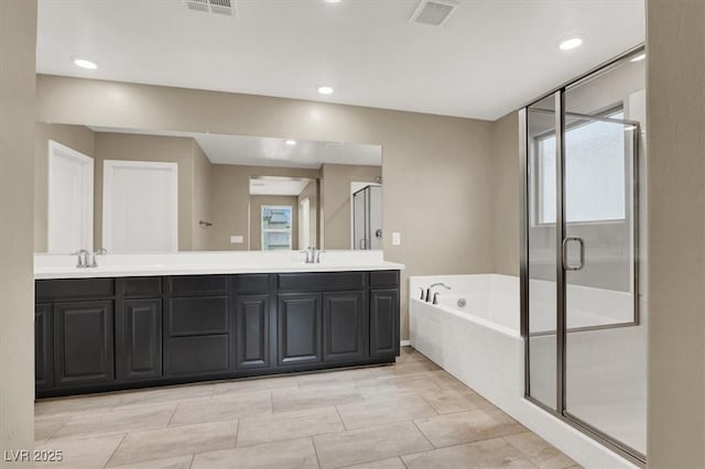 bathroom featuring a stall shower, double vanity, visible vents, and a bath