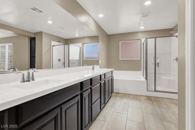 bathroom with double vanity, visible vents, a bath, a shower stall, and a sink