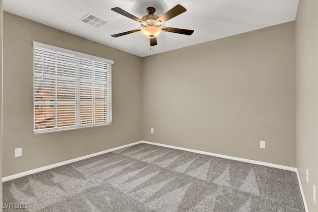 unfurnished room with carpet floors, baseboards, visible vents, and ceiling fan