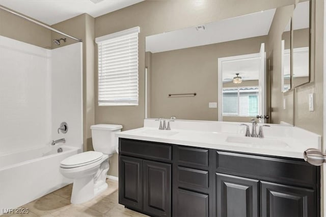 bathroom featuring toilet, double vanity, a sink, and bathing tub / shower combination