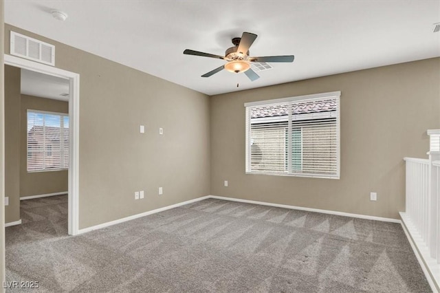 spare room with a wealth of natural light, visible vents, and carpet flooring