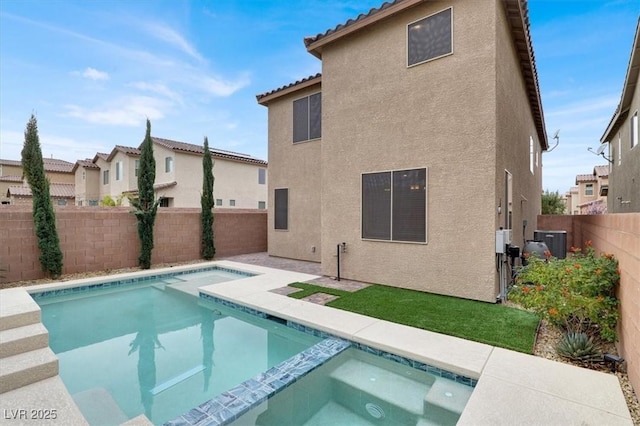 back of property featuring a fenced backyard, central AC, a pool with connected hot tub, a tiled roof, and stucco siding