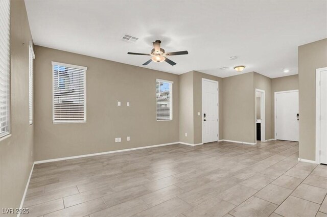 spare room featuring baseboards, visible vents, and a ceiling fan