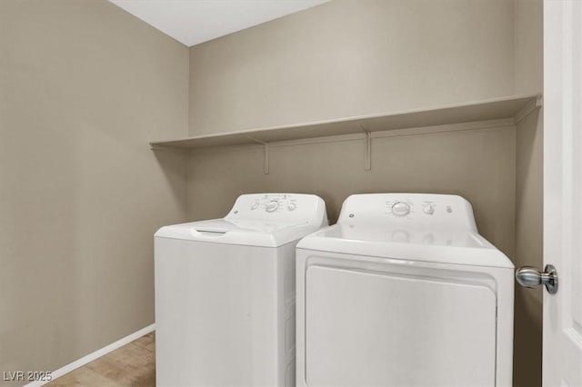 clothes washing area featuring laundry area, washing machine and dryer, and baseboards