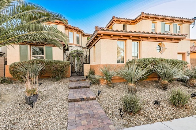 view of front of house with a gate and stucco siding