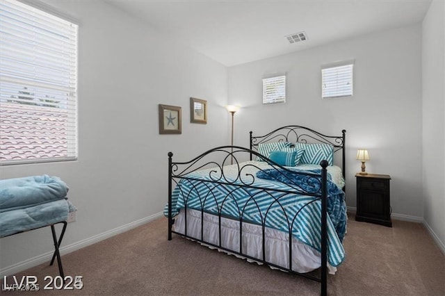 carpeted bedroom with visible vents and baseboards