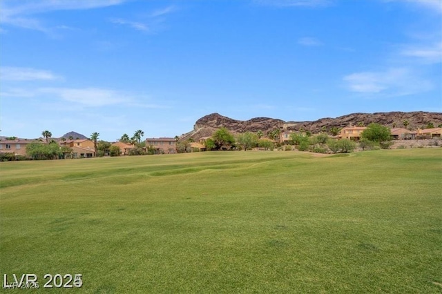 view of community with a lawn and a mountain view