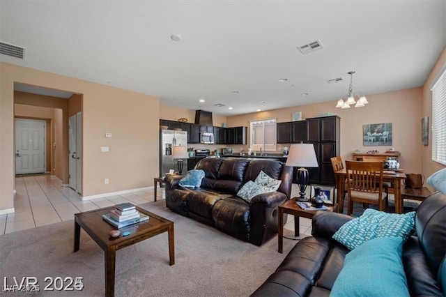 living area featuring visible vents, a notable chandelier, baseboards, and light tile patterned flooring