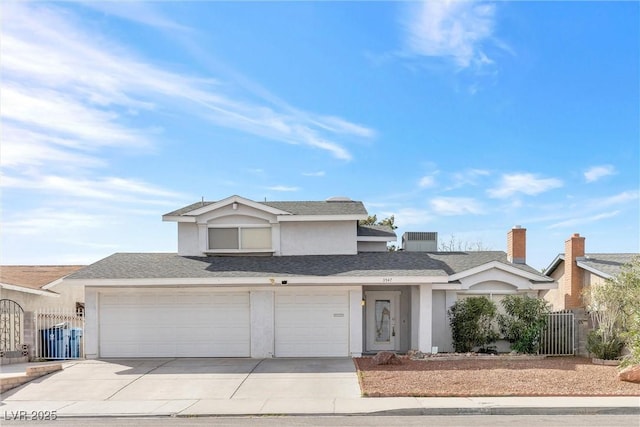 traditional home with a gate, concrete driveway, and stucco siding