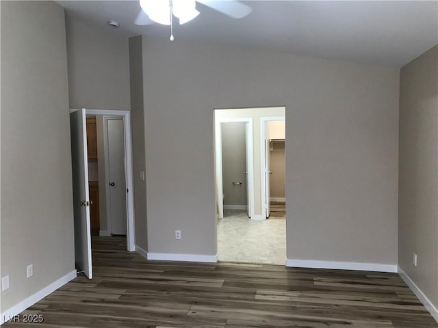 interior space with wood finished floors, a ceiling fan, and baseboards