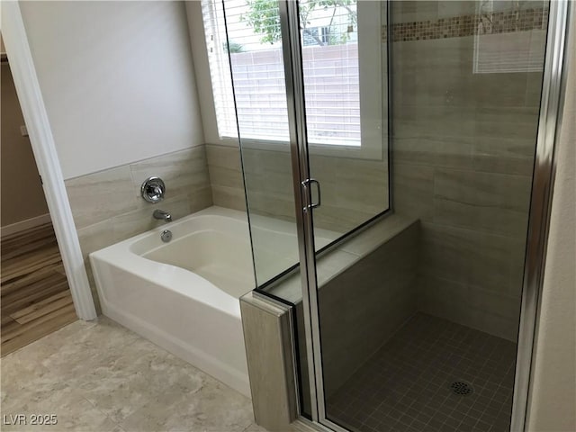 full bath featuring a garden tub and a shower stall