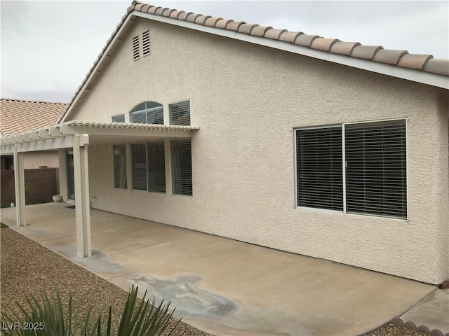 view of home's exterior featuring stucco siding, a patio, and a pergola