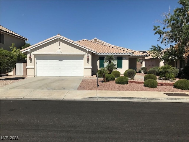 331 Mount Hope St, Henderson, NV 89014 - view of front of home featuring a tile roof, stucco siding, an attached garage, and concrete driveway