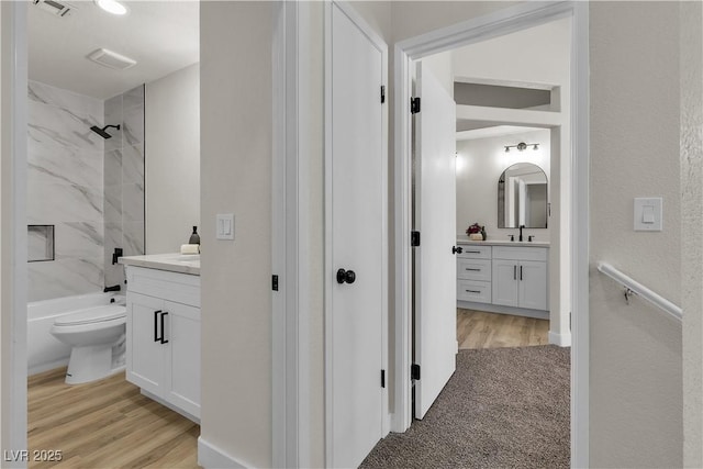 full bathroom with bathing tub / shower combination, wood finished floors, and vanity