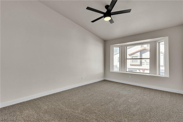 carpeted spare room with lofted ceiling, ceiling fan, and baseboards