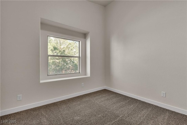 unfurnished room featuring dark carpet and baseboards