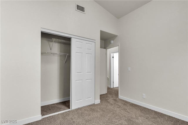 unfurnished bedroom with baseboards, a closet, visible vents, and carpet flooring