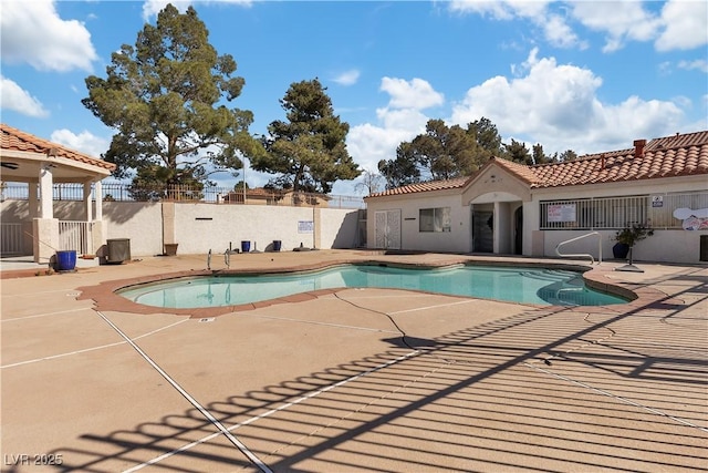 pool with a patio area and fence