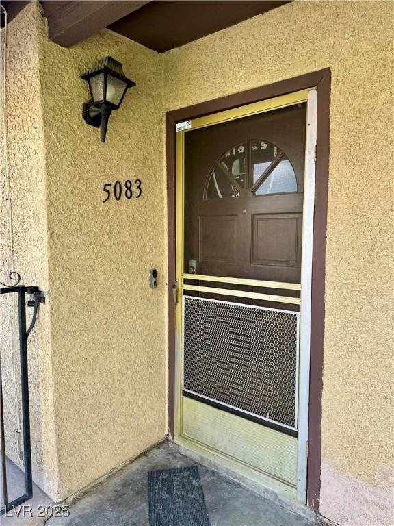 doorway to property featuring stucco siding