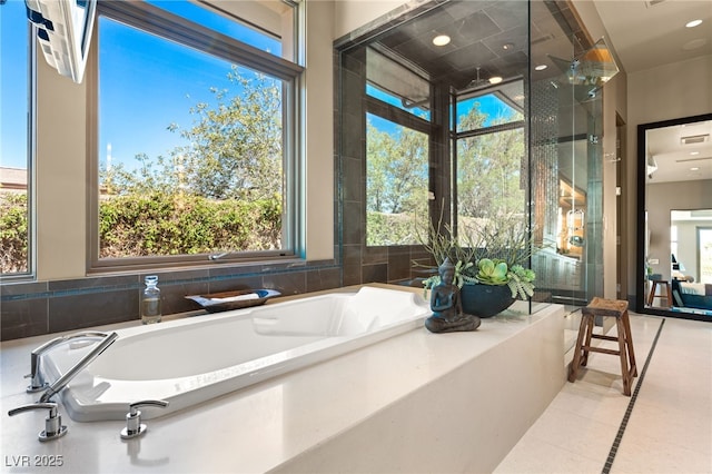 bathroom featuring a garden tub and tile patterned flooring