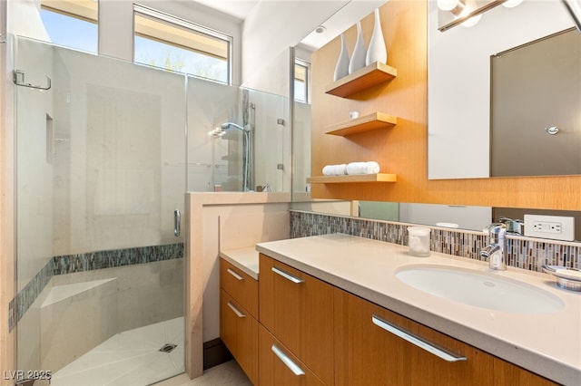 full bath featuring a stall shower, decorative backsplash, and vanity