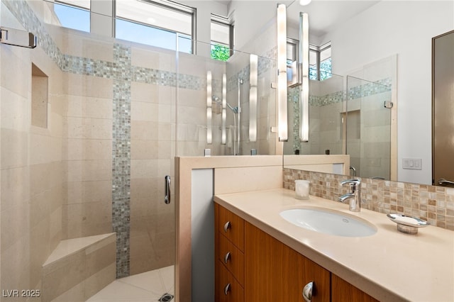 full bathroom with a stall shower, tasteful backsplash, and vanity