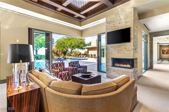 living room featuring an outdoor stone fireplace, coffered ceiling, beamed ceiling, and tile patterned floors