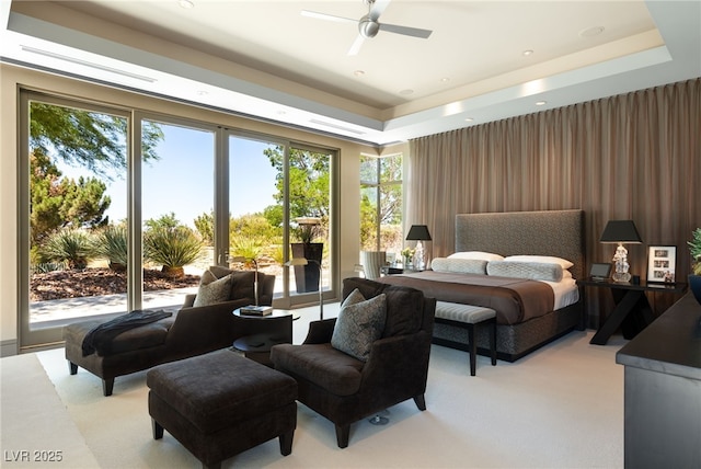 bedroom with recessed lighting, a tray ceiling, and light colored carpet