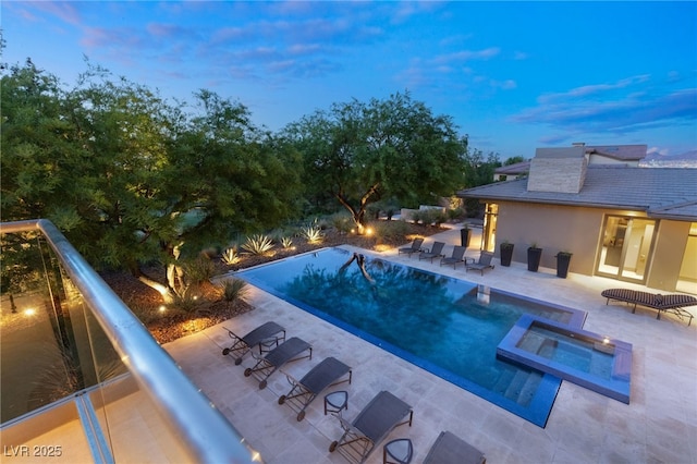 view of swimming pool featuring a pool with connected hot tub and a patio