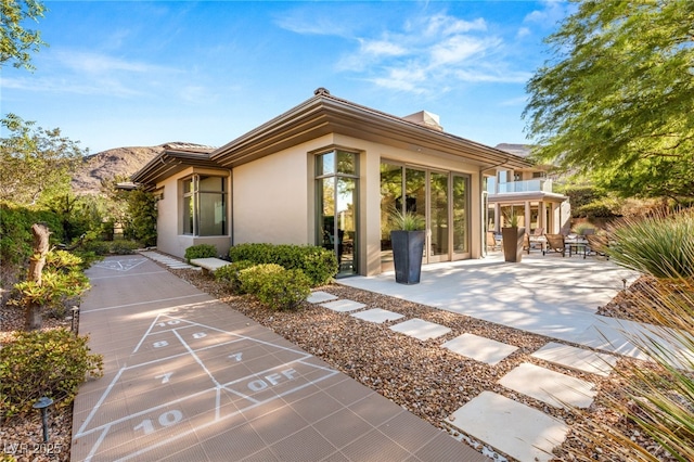 exterior space featuring a mountain view, a patio, and shuffleboard