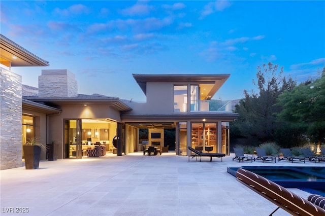 back of house with a patio area, a balcony, and stucco siding