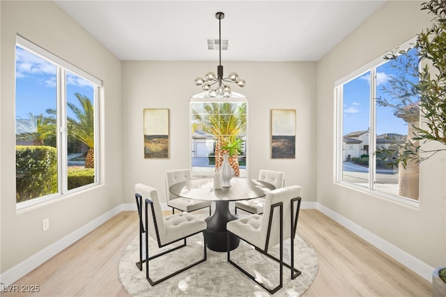 dining area featuring light wood-type flooring, baseboards, and visible vents