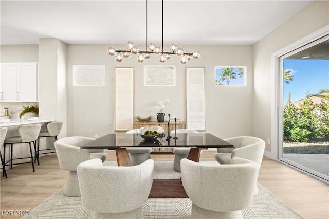 dining room featuring light wood-style flooring and a notable chandelier