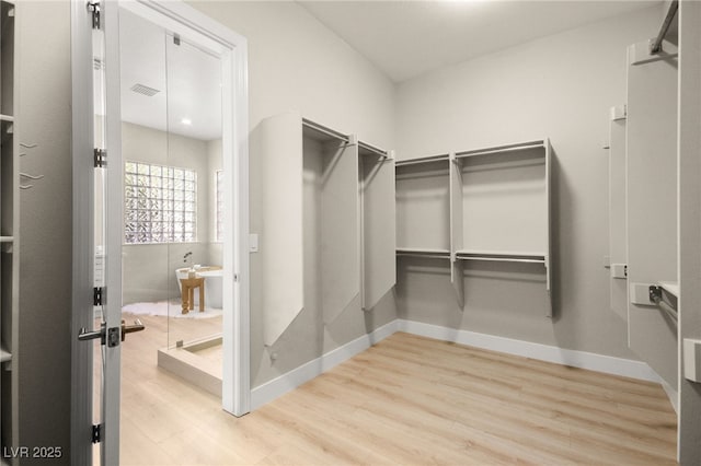 spacious closet featuring visible vents and wood finished floors