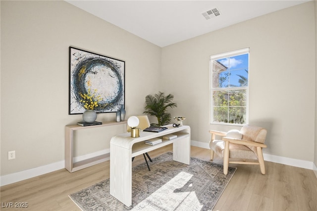 office featuring light wood-type flooring, visible vents, and baseboards