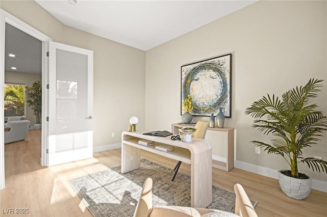 office with light wood-type flooring and baseboards