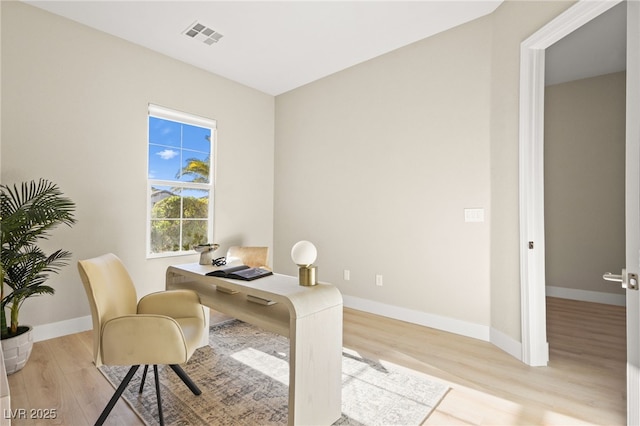 office featuring wood finished floors, visible vents, and baseboards