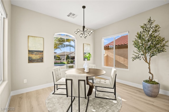 dining room with a healthy amount of sunlight, light wood-style floors, baseboards, and visible vents