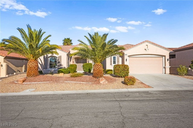 view of front of house with an attached garage, concrete driveway, and stucco siding