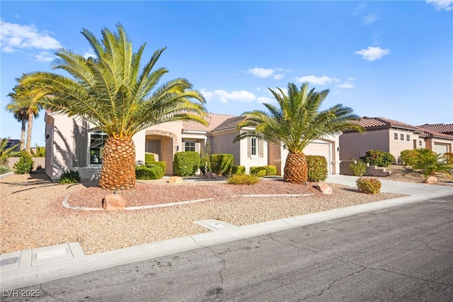 view of front facade featuring a garage, concrete driveway, and stucco siding