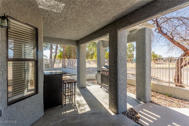 view of patio featuring a grill and fence