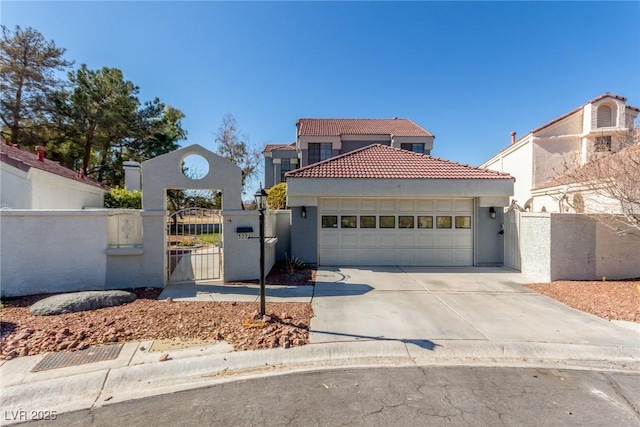 mediterranean / spanish-style home featuring an attached garage, a tile roof, fence, concrete driveway, and a gate