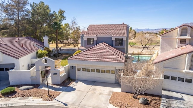 view of front of house with a tiled roof, driveway, a gate, and stucco siding