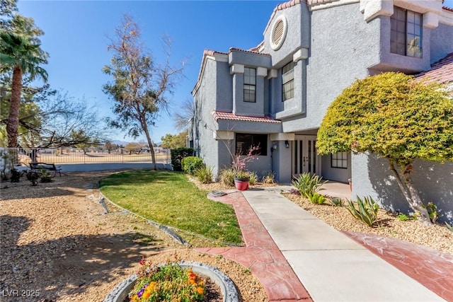 exterior space with a tile roof, fence, french doors, and stucco siding