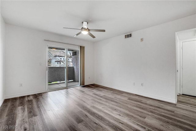 unfurnished room with wood finished floors, visible vents, and baseboards