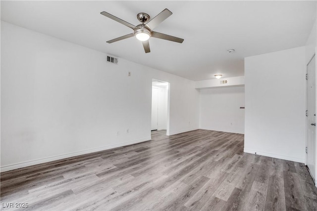 unfurnished room featuring visible vents, baseboards, a ceiling fan, and wood finished floors