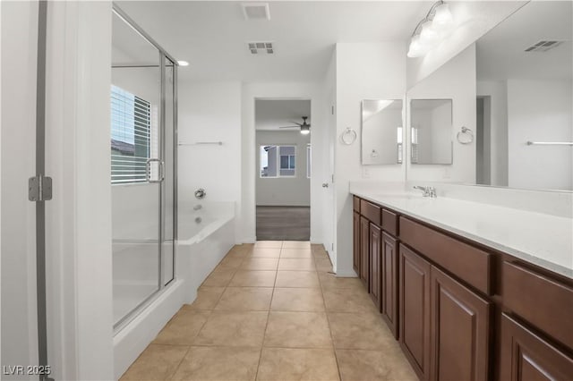 bathroom with a stall shower, visible vents, tile patterned floors, vanity, and a wealth of natural light