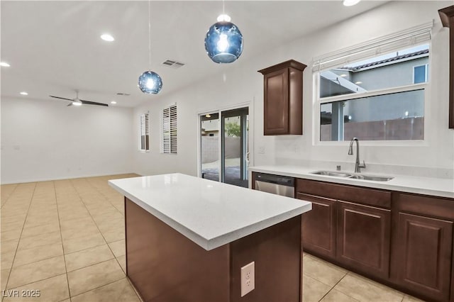 kitchen featuring a kitchen island, light countertops, a sink, and dishwasher